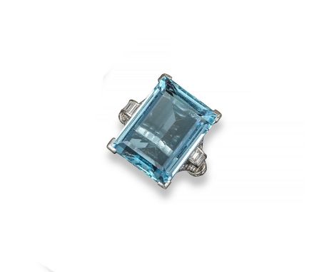 An aquamarine and diamond ring, the large emerald-cut aquamarine is set within scrolling shoulders set with graduated baguett