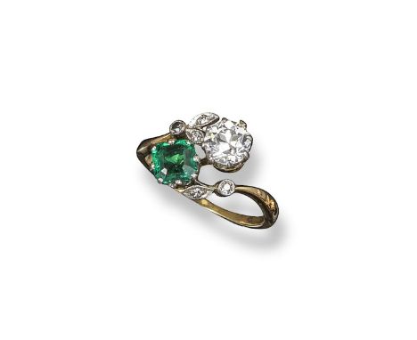 An emerald and diamond cross-over ring, set with a circular-cut diamond and a square-shaped emerald, within millegrain-set di