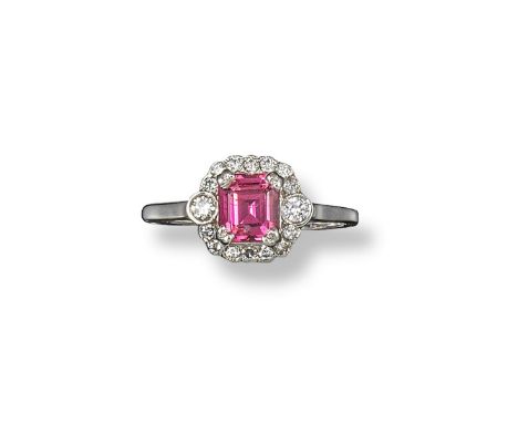 A pink tourmaline and diamond ring, the emerald-cut tourmaline is set within a surround of small circular-cut diamonds, with 