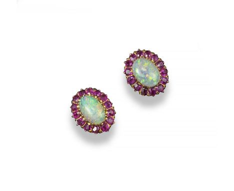 A pair of opal and ruby cluster ear studs, the solid white cabochon opals are set within a surround of rubies in yellow gold.