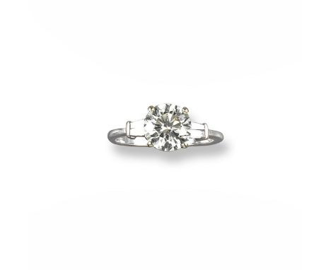 A diamond solitaire ring, the round brilliant cut diamond weighs 2.12cts and is set in 18ct white gold with four tapered bagu