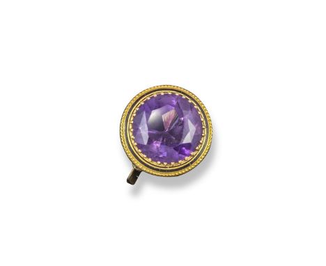 An amethyst mounted gold ring, the large circular-cut amethyst is set within yellow-gold collet surround and a ring of black 