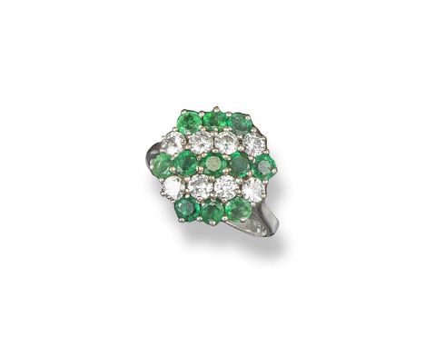 An emerald and diamond cluster ring, of hexagonal form and set with lines of circular-cut emeralds and diamonds in white gold