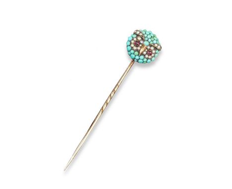 An owl's head stick pin, the circular head pavé-set with graduated turquoise cabochons, seed pearls and cabochon ruby eyes. W