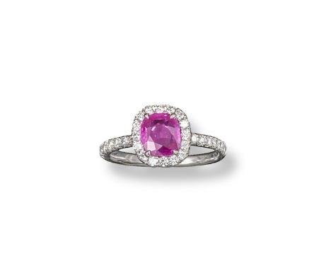 A Burmese ruby and diamond cluster ring, the cushion-shaped ruby is set within a surround of smaller circular-cut diamonds an