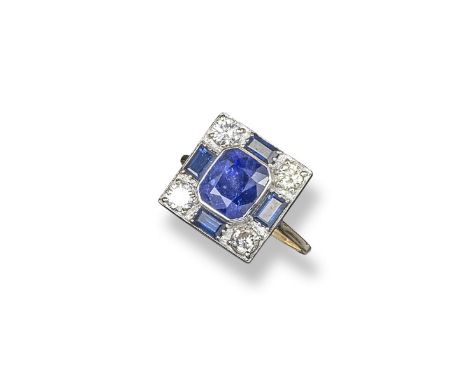 A sapphire and diamond cluster ring, the emerald-cut sapphire is set within sapphire and diamond chequerboard surround in pla