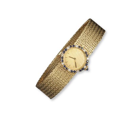 A lady's gem-set gold wristwatch by Boucheron, the textured gold dial with baton numerals, within a surround of sapphires and