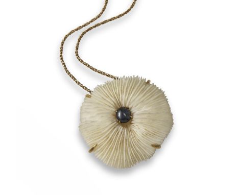 A gem-set gold pendant by Andrew Grima, the uncarved coral section is mounted with a central sapphire cabochon and mounted in