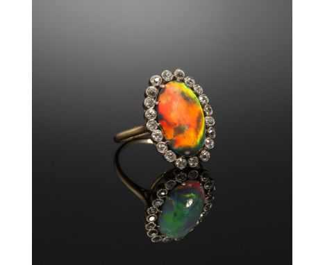 A Lightning Ridge solid black opal and diamond cluster ring, the black opal cabochon weighs approximately 5.00cts and is set 