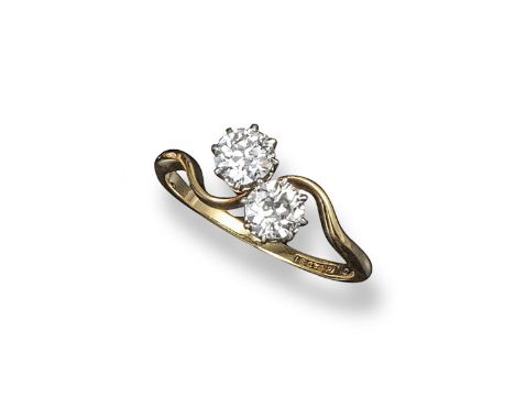 A diamond two stone cross-over ring, the circular-cut diamonds weigh approximately 1.00cts in total. Set in yellow gold. Size