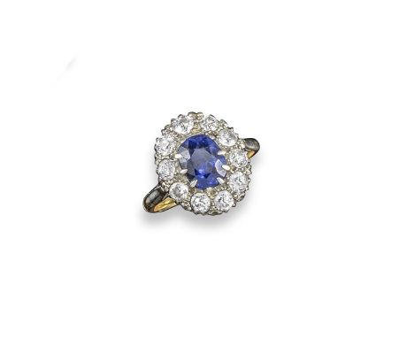 A Burmese sapphire and diamond cluster ring, the oval-shaped sapphire is set within a surround of  old circular cut diamonds 