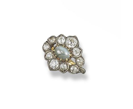 A catseye and diamond ring, the oval catseye cabochon is set within a foliate surround of cushion-shaped diamonds in silver a