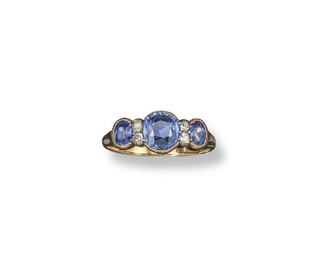 A sapphire and diamond half hoop ring, set with three oval-shaped sapphires and four smaller diamonds in yellow gold. Size P.