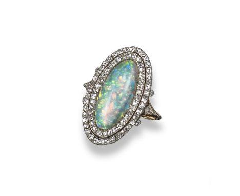 An opal and diamond cluster ring, the marquise-shaped solid white opal cabochon is set within concentric surrounds of circula