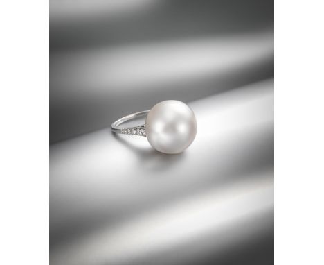 An impressive natural saltwater pearl ring, the French platinum mount is set with small shoulder diamonds and with a control 