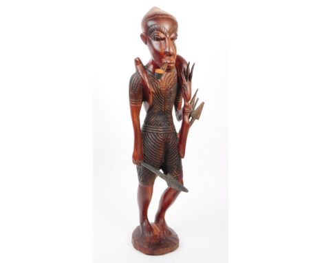 Vintage 20th century hand carved African tribal statue. The huntsman has spear with animal over shoulder whilst smoking a pip