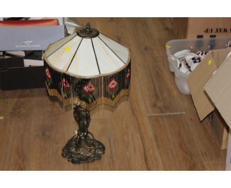 A cast metal figural table lamp with beaded and smoked glass shade 