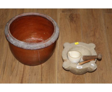 A large cut carved stone pestle and mortar together with a smaller ceramic version and a large stone ware vessel
