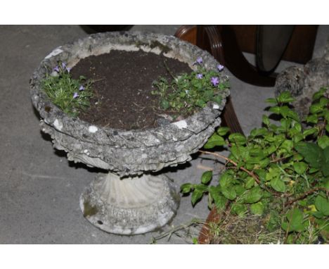 A floral and crusted stone garden planter on pedestal 