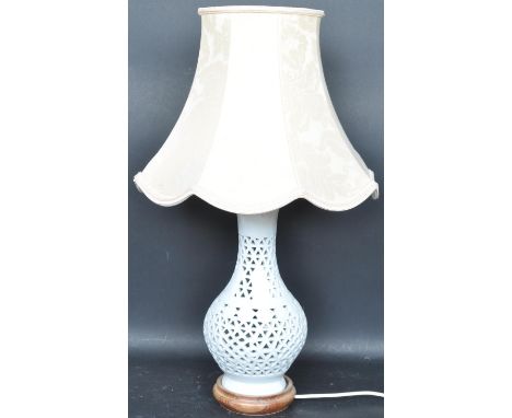 A 20th century Blanc de Chine ceramic table lamp having a pierced body with lattice work decoration. Measures 62cm.