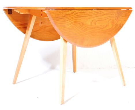 
Ercol - Lucien Ercolani. A retro vintage 1970s light beech and elm drop leaf dining table of circular form having a chamfere