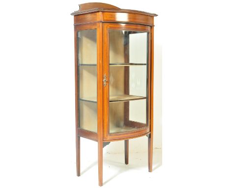 An early 20th century Edwardian mahogany inlaid bow fronted display cabinet vitrine having an arched gallery back, flared cha