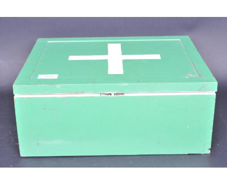 A vintage 20th century medical first aid box of wooden construction with green painted exterior and white appointed interior.
