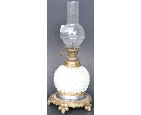 A 19th century Victorian oil paraffin lamp having a glass flue to the top, over a white hobnail glass body raised on a circul