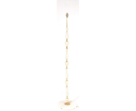 A mid 20th century brass and onyx floor standing standard lamp upon a circular base. Measures 154cm tall.&nbsp;