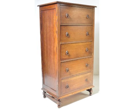 A good 1920's oak upright chest of drawers / tallboy. Raised on squared legs with an upright back of 5 deep drawers having dr