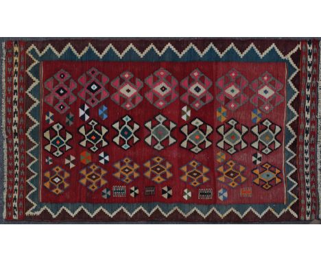 A 20th century wool on wool hand knotted southwest Persian Qashgai Kilim rug / carpet. The rug having a red field decorated w