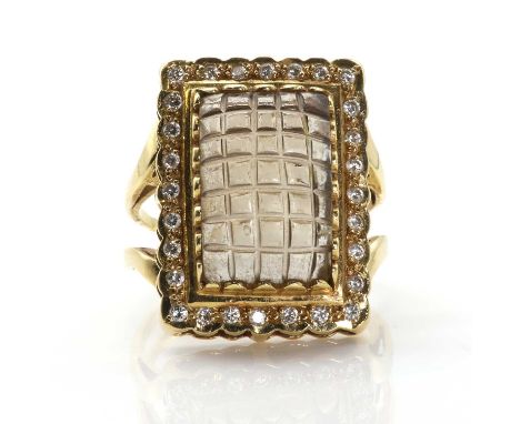 A carved smoky quartz and diamond cluster ring,  with a rectangular carved smoky quartz claw set to the centre. A border of r