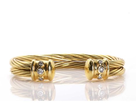 An 18ct gold diamond set twist rope design torque bangle,the two row twisted wire open bangle, with polished terminals set wi