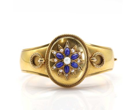 A Victorian gold, lapis lazuli and pearl hinged bangle with double-sided locket,the front with a lapis lazuli, half pearl and