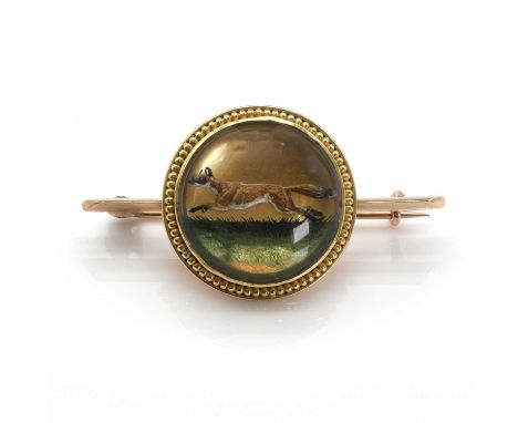 A reverse painted crystal intaglio hunting brooch,a circular cabochon rock crystal, reverse painted with a running fox, bezel