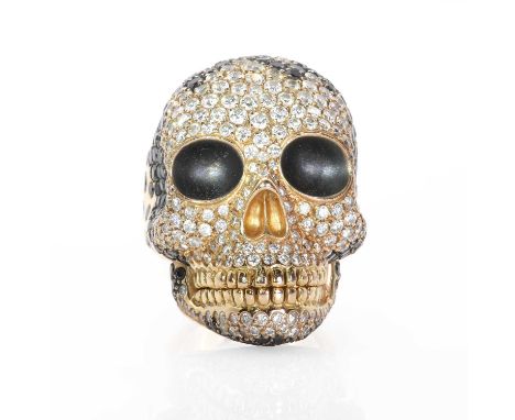 A large diamond and black diamond skull ring,  the realistically modelled skull stamped '750' and tested as 18ct gold, with h