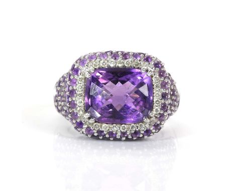 14ct white gold and amethyst and diamond cluster ring, centring a claw set cushion shaped checkerboard cut amethyst within a 