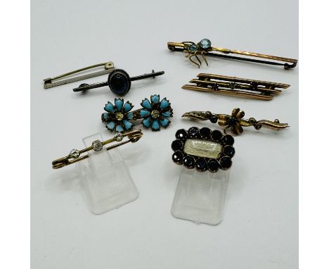 A collection of eight antique and vintage brooches. Featuring a Georgian mourning brooch, set with closed back amethysts and 