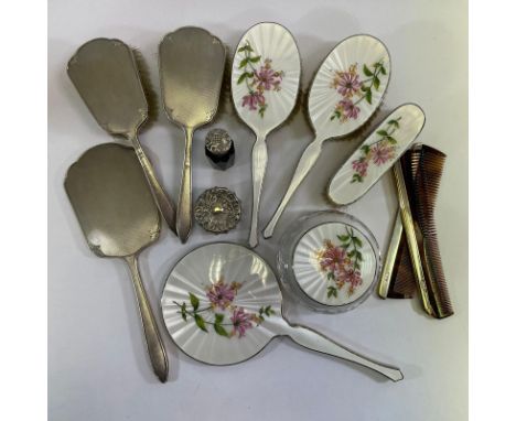 A silver enamel five piece dressing table set and a three piece dressing table set.&nbsp; A brush, two combs and 2 bottles wi