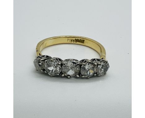 A five stone diamond ring, featuring five graduated old cut diamonds. In precious yellow metal marked "18ct" and "750". The c