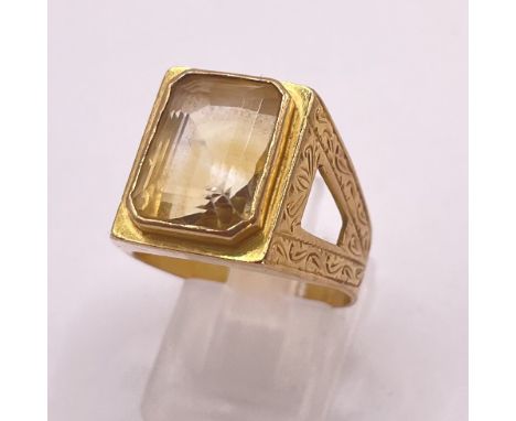 A Chinese precious yellow metal gentleman's signet ring. Engraved with foliate patters and set with an emerald cut citrine. S