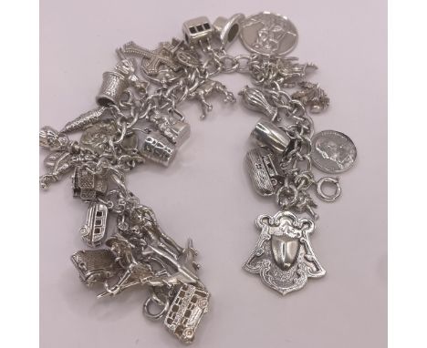 A silver charm bracelet. Approximately 107 grams. With 31 charms that include: Noah's Ark, London Boss, camera, top hat, this