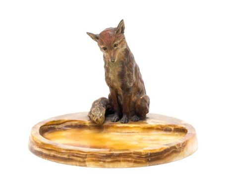 An Australian cold painted bronze fox, modelled seated atop a variegated marble vide poche of circular form, fox 15cm high. 