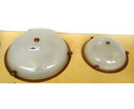 A pair of brass and frosted glass ceiling lights of domed form, mounted with four engine turned bosses supporting a foliate e