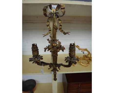 A pair of gilt bronze two branch wall lights of Georgian style, each cast with ribbon surmounts over a fluted, foliate body, 