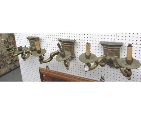 A set of three bronze two branch wall lights of Victorian Gothic style, early 20th century, the shaped backplates issuing two