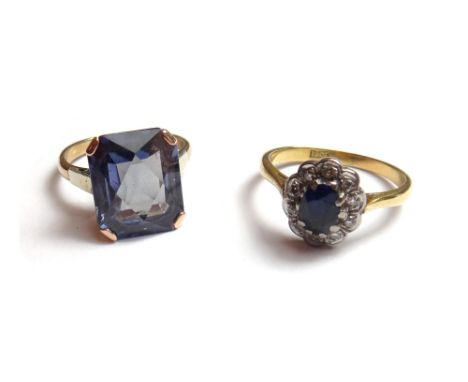 A gold, sapphire and diamond set oval cluster ring, claw set with the oval cut sapphire at the centre, within a surround of t