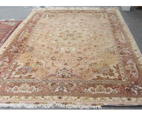 A part silk Tabriz carpet, Persian, the beige field with a pale central roundel, matching spandrels, all with delicate floral