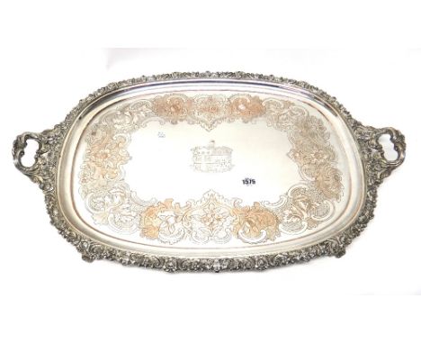A Sheffield plated twin handled tray, the centre engraved with a coat of arms, within a floral, foliate and scroll engraved s