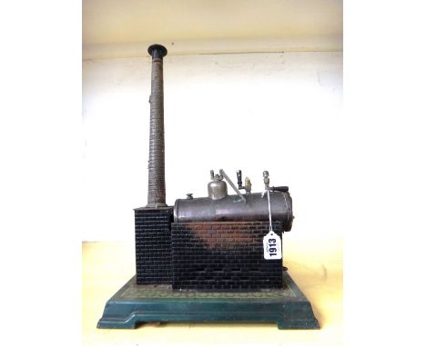 A tinplate model steam engine, 20th century with boiler, funnel and separate fly-wheel, all mounted on a square stepped base,